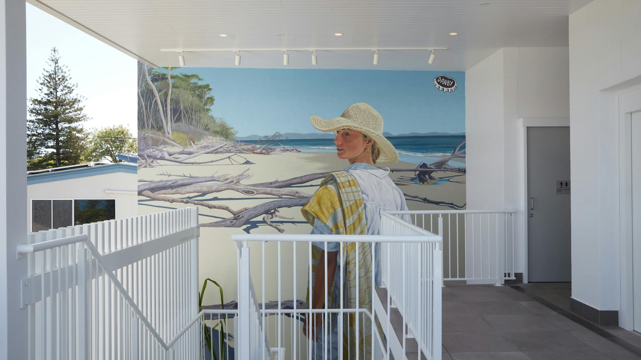 Mural of lady walking on a beach surrounded by driftwood