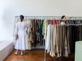 Femme person in a white dress browsing the racks.