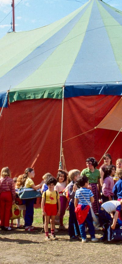 Coloured photograph of The Flying Fruit Fly Circus with crownds gathered outside the circus tent