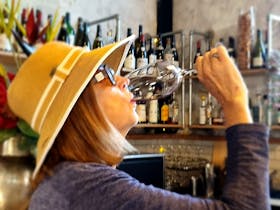 Lady with hat on drinking red wine