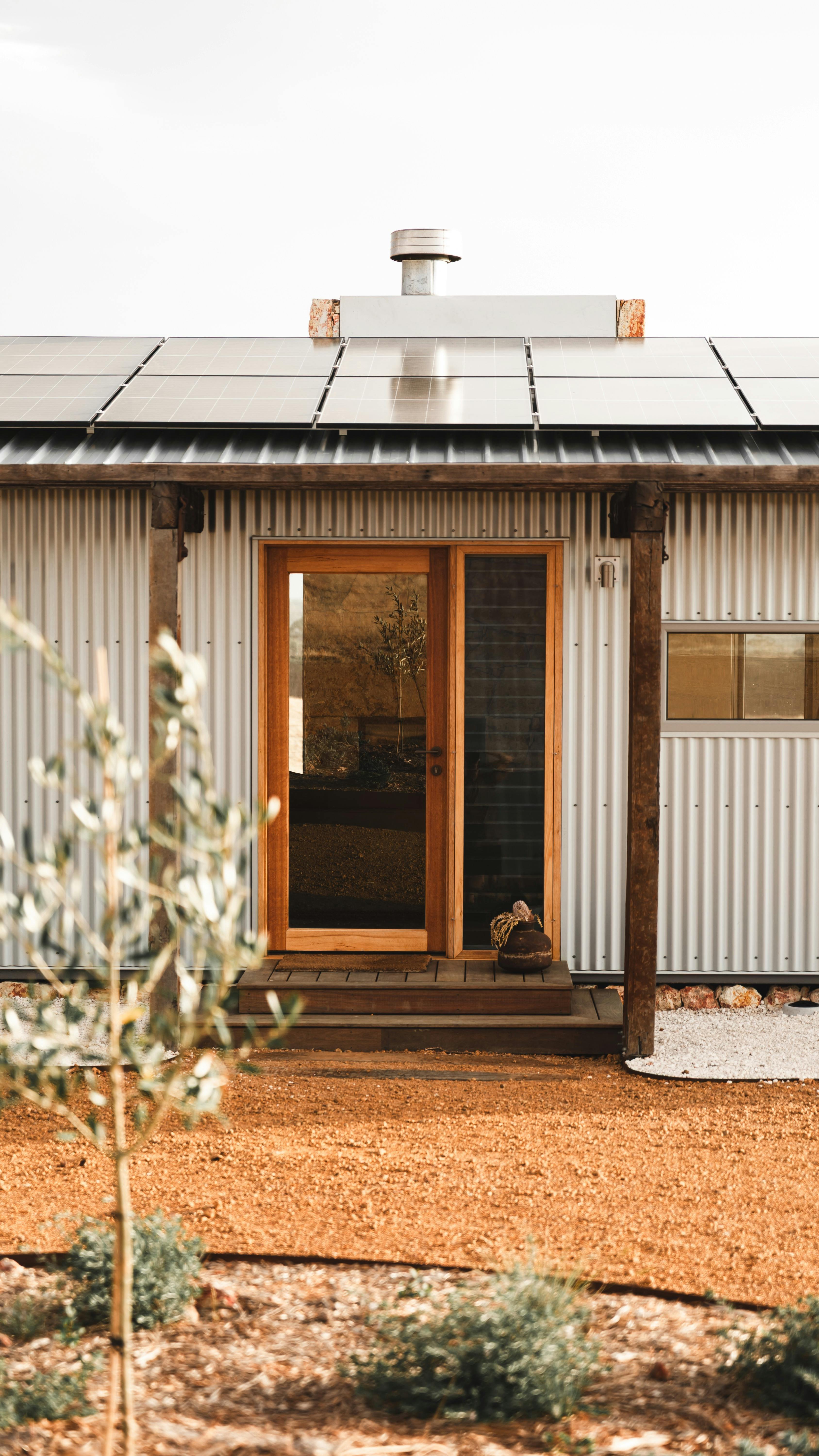 Cabin entrance with olive tree in foreground