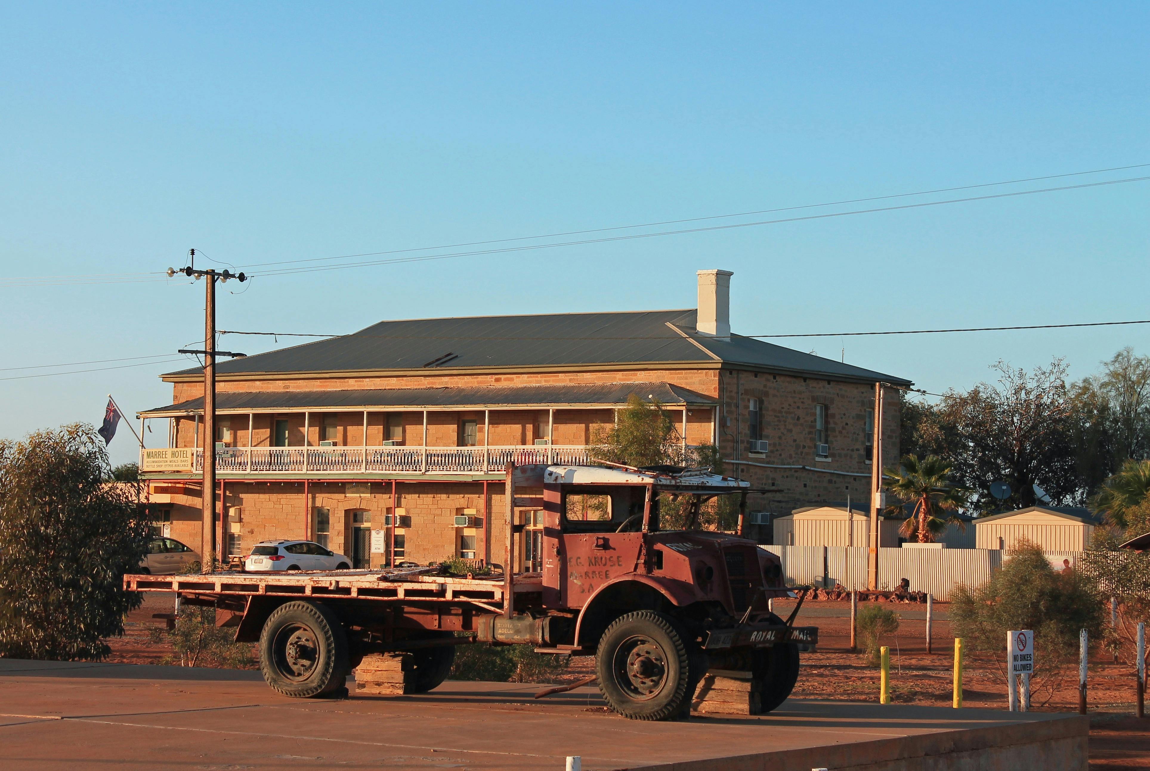 A tradional Outback Pub and old trucks parked in front