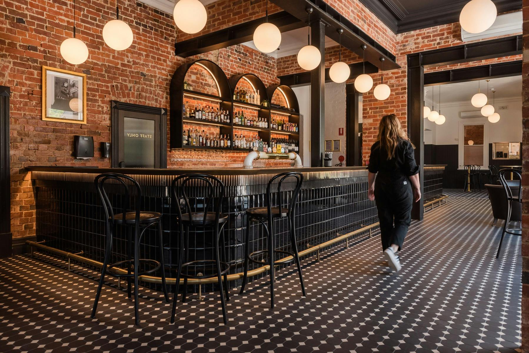 Modern bar with brick wall and black and white tiles