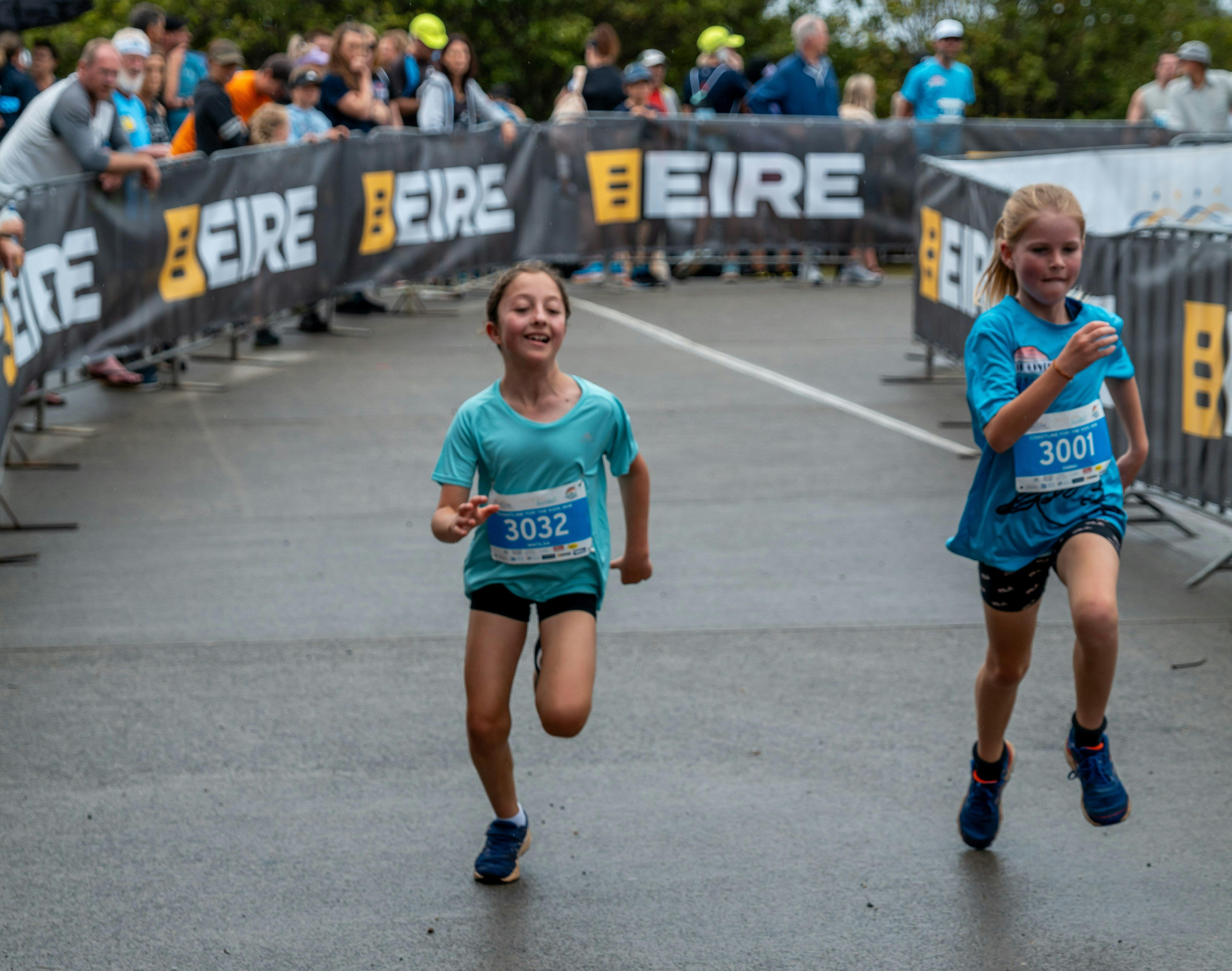 Two female kids finishing their race.