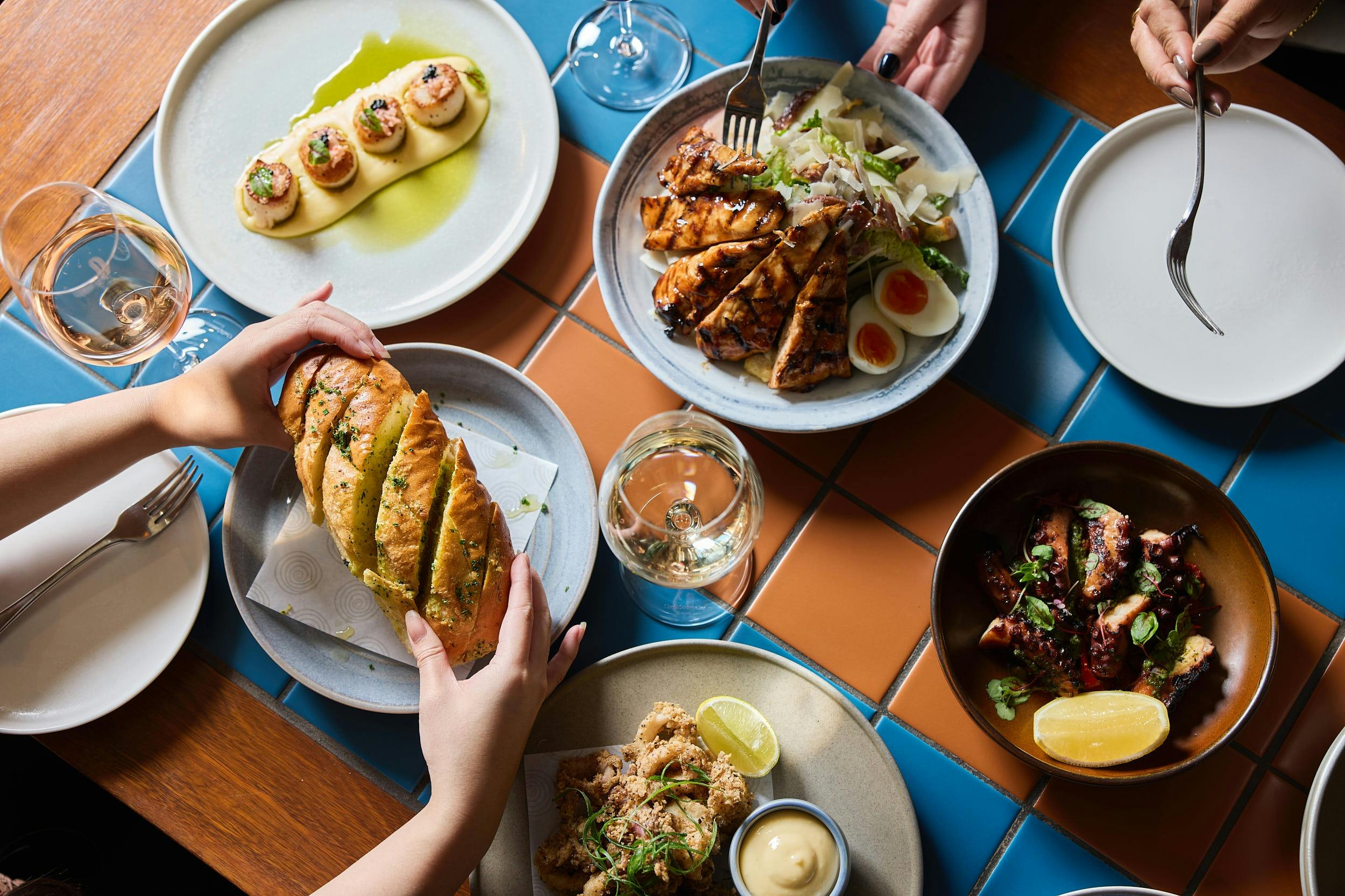 Hurricane's Grill & Bar garlic bread, caesar salad and plates of seafood