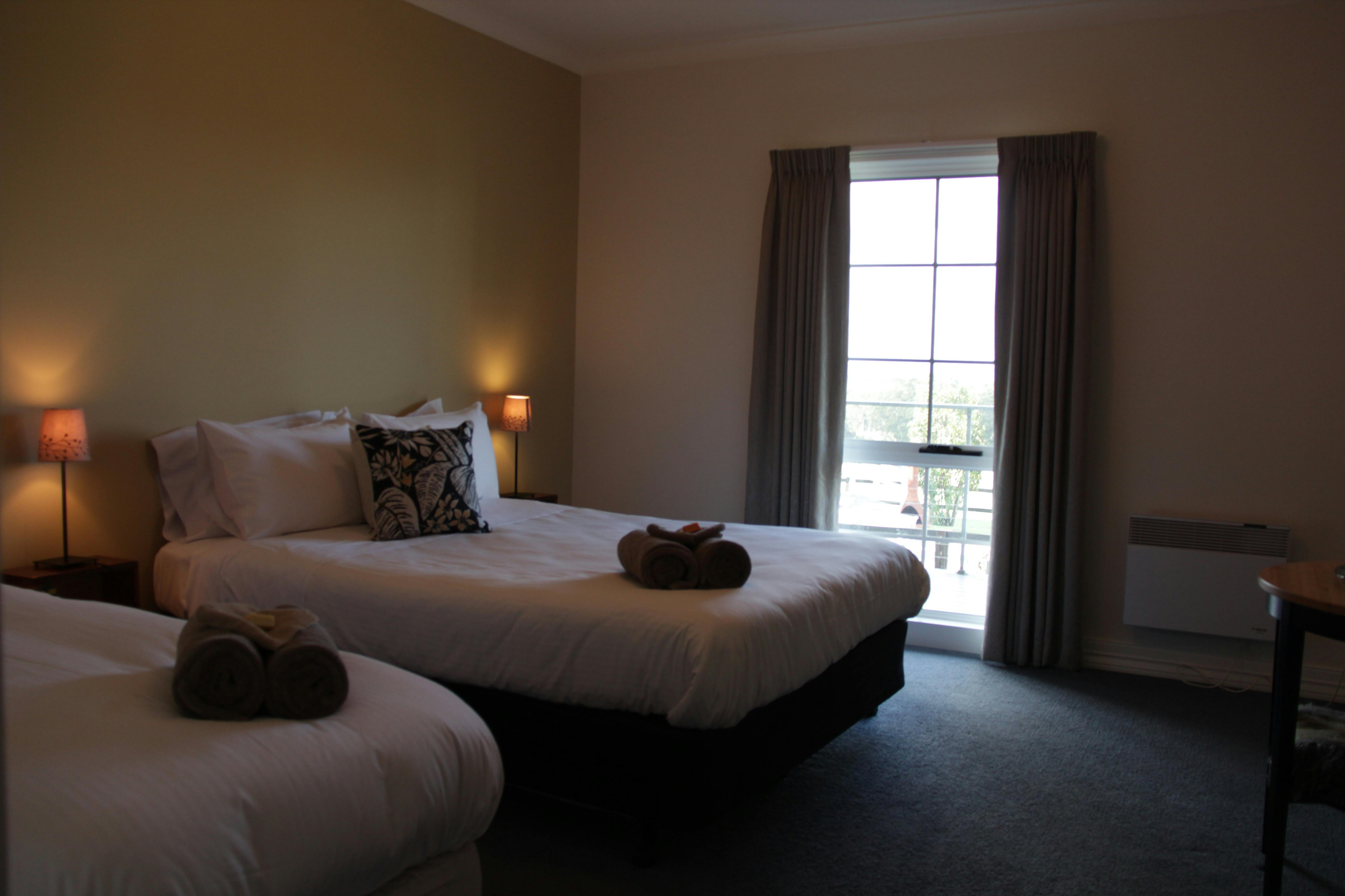 Queen size bed and a single bed in a room with a gold wall