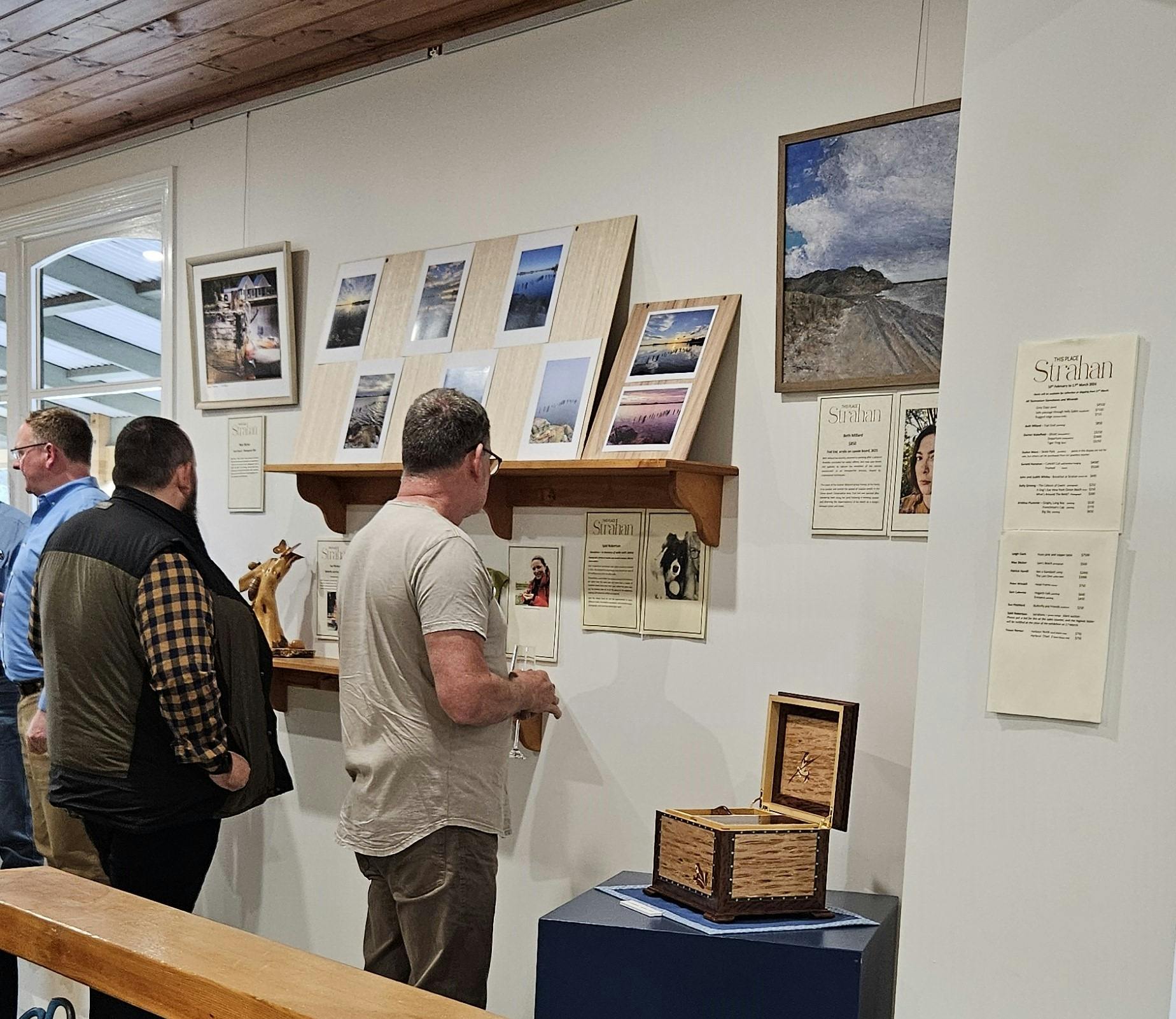 People looking at pictures on a wall