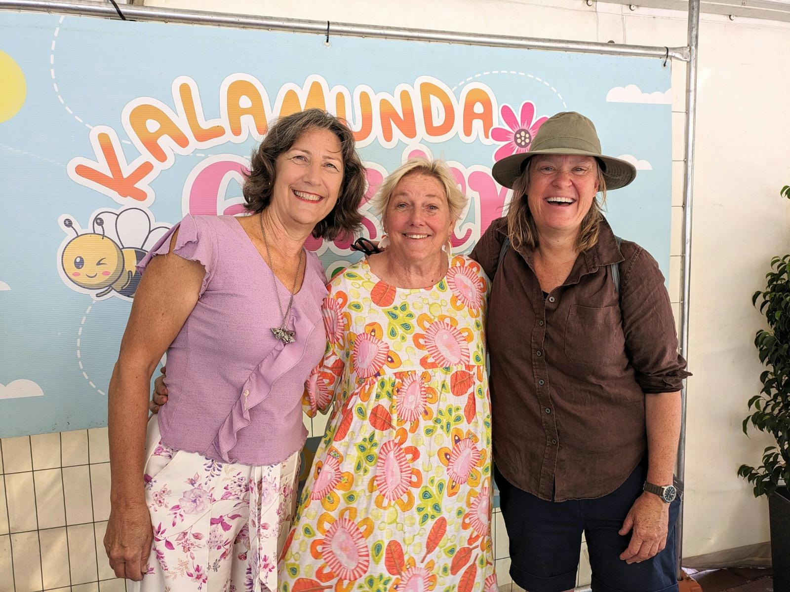 Faye Arcaro, Sabrina Hahn and Millie Ross in front of the festival sign.