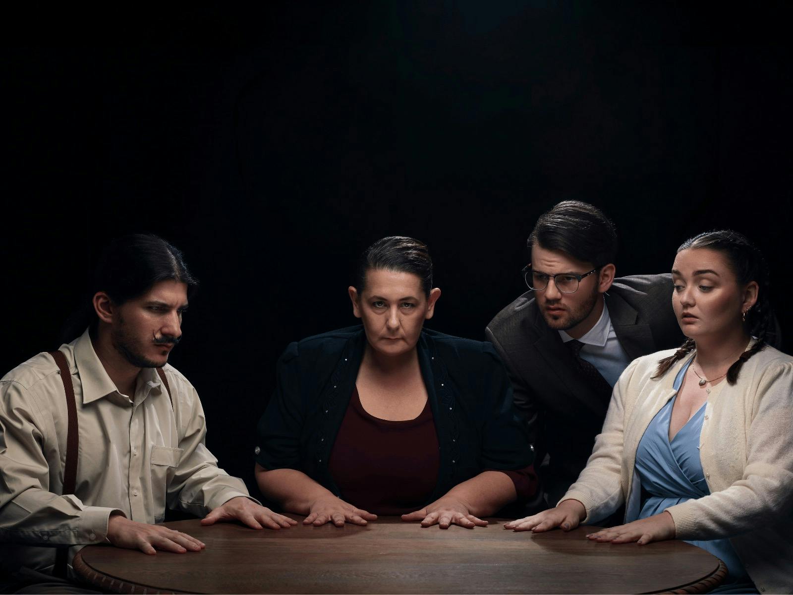 A group of four people sitting around a table in a seance.
