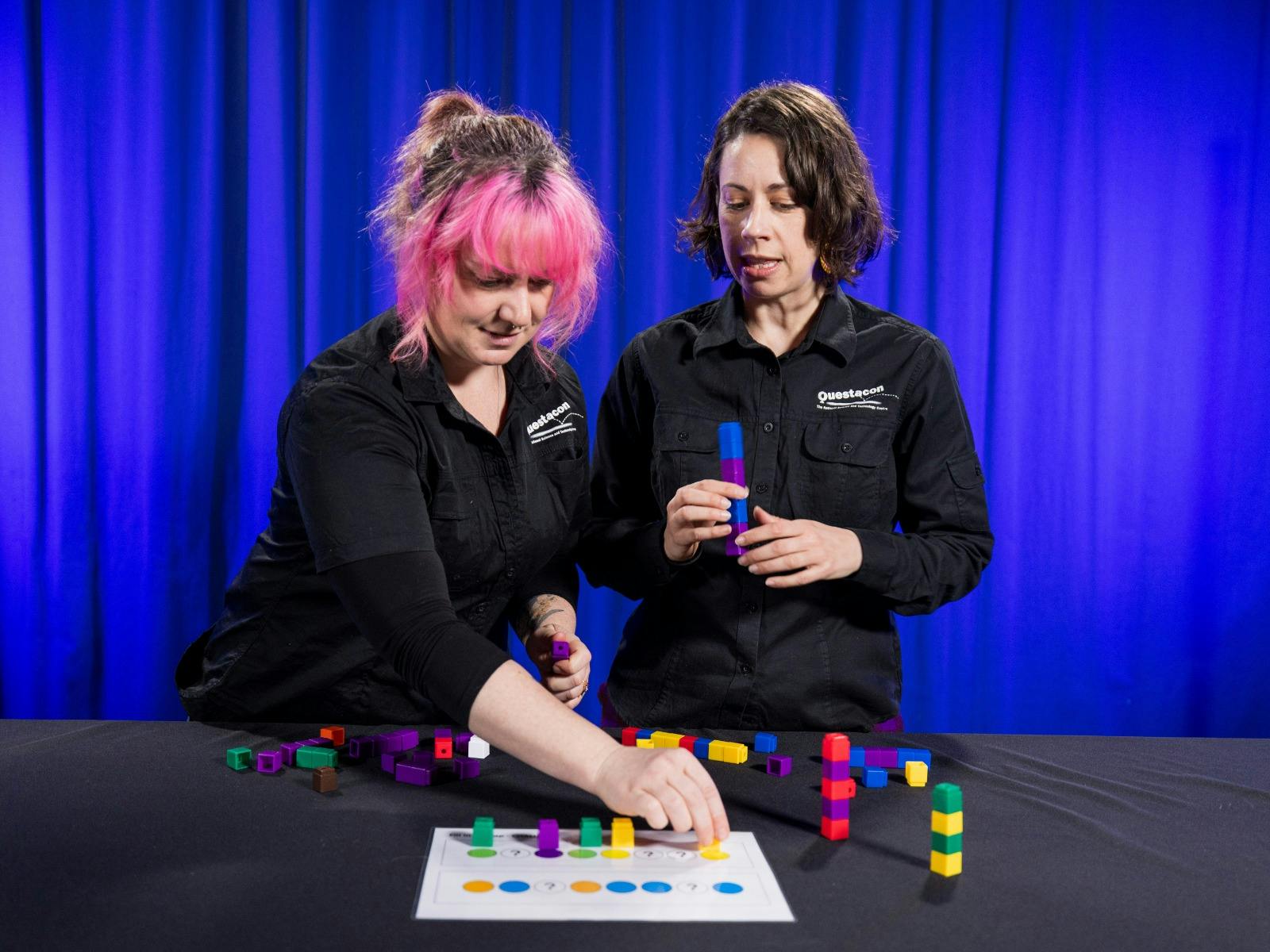 Two women explore patterns using coloured blocks