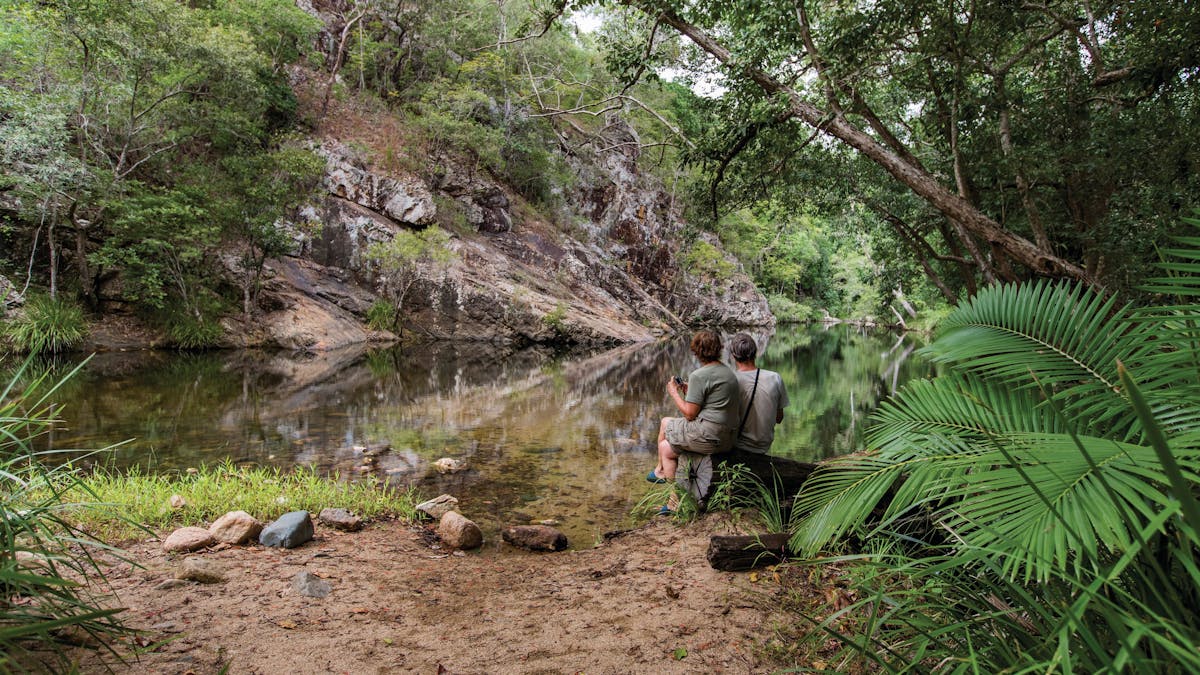 Couple sitting on log beside Waterview Creek.