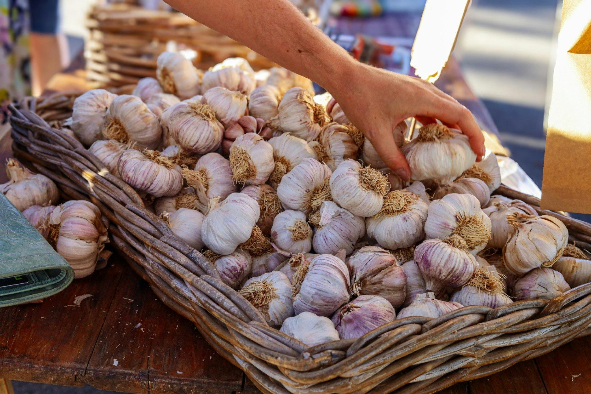 someone picking garlic from a basket