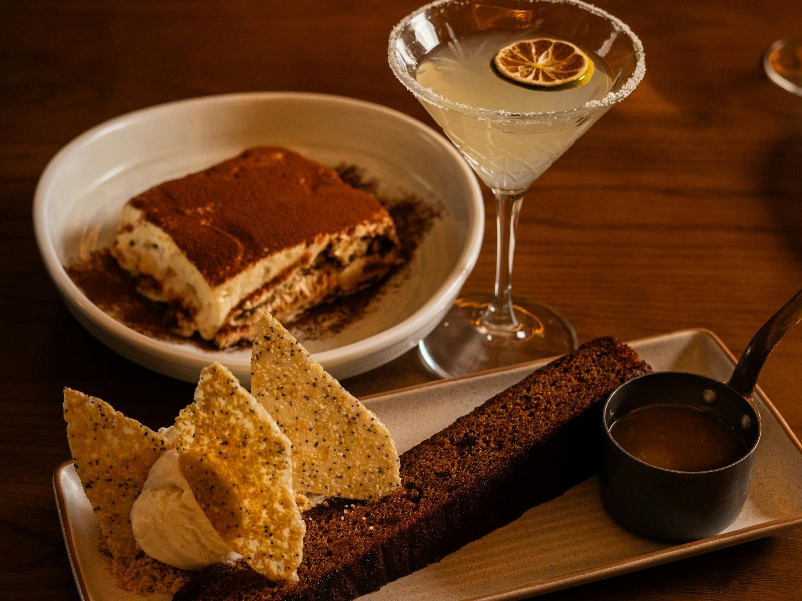 image of sticky date pudding and tiramisu with a cocktail on a table