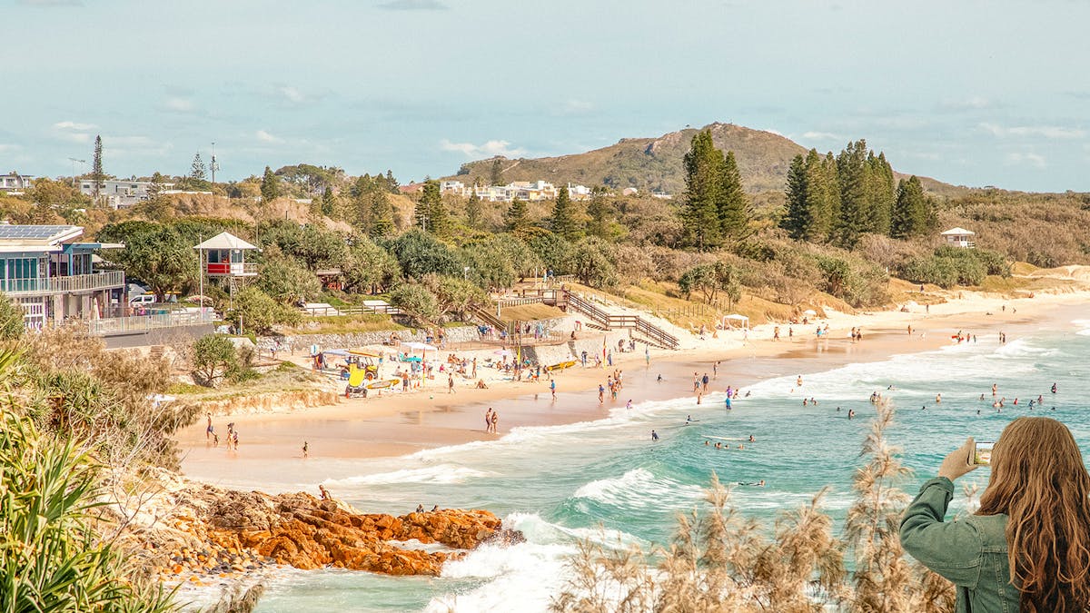 Long shot of Coolum Beach looking north from the boardwalk to Emu Mountain.