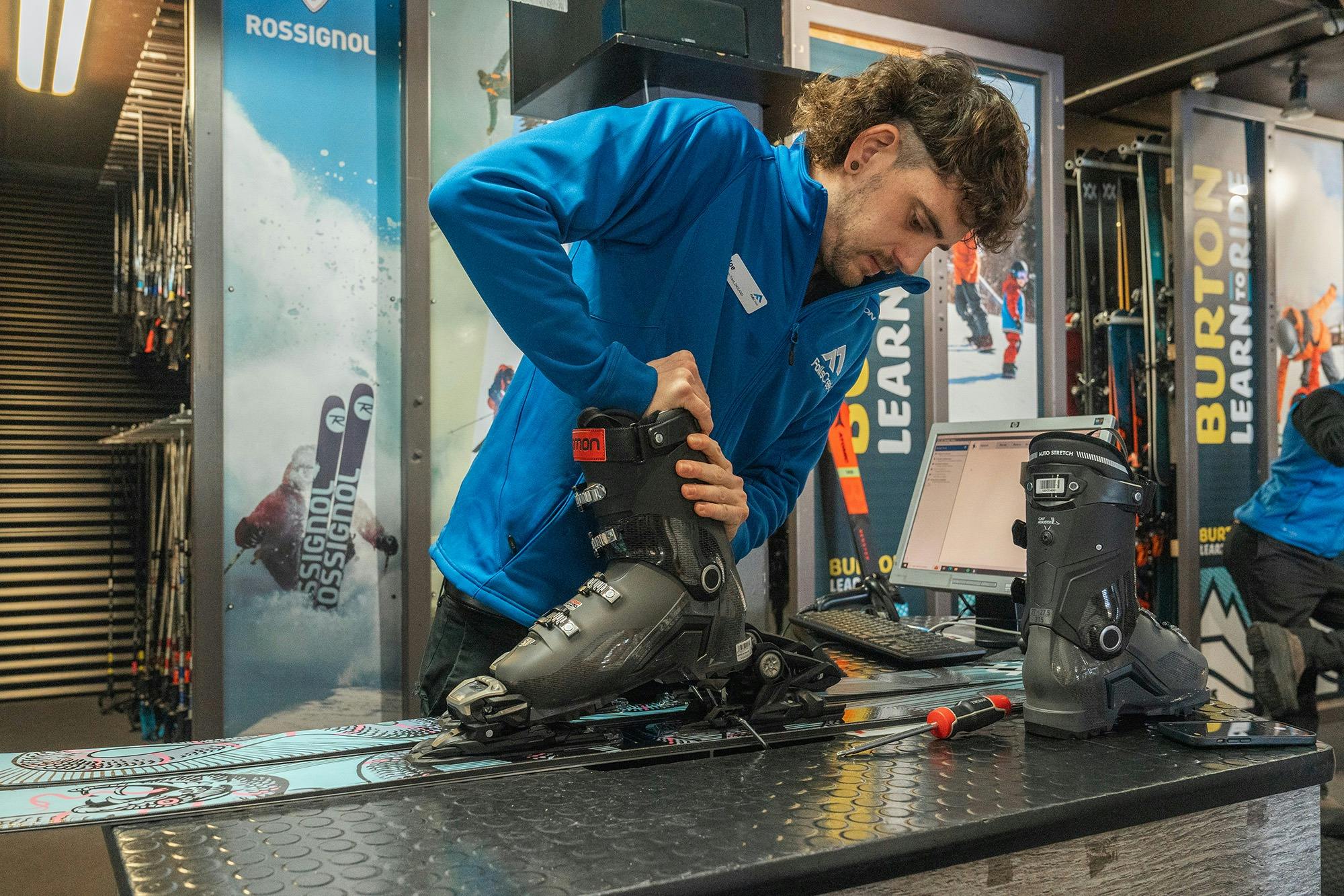 Man fitting boots to rental skis