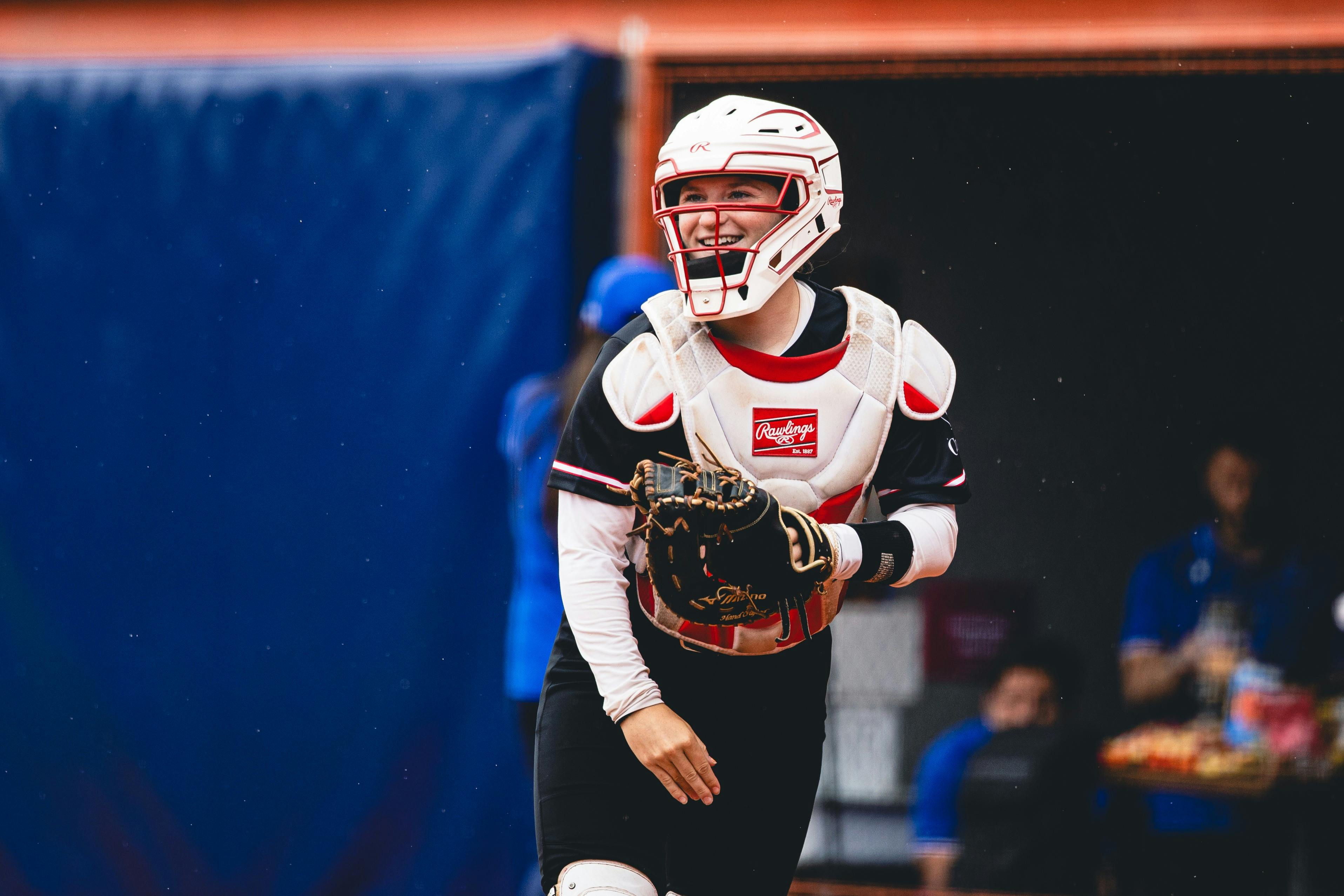 Softball catcher in protective gear prepares for play during an international tournament.