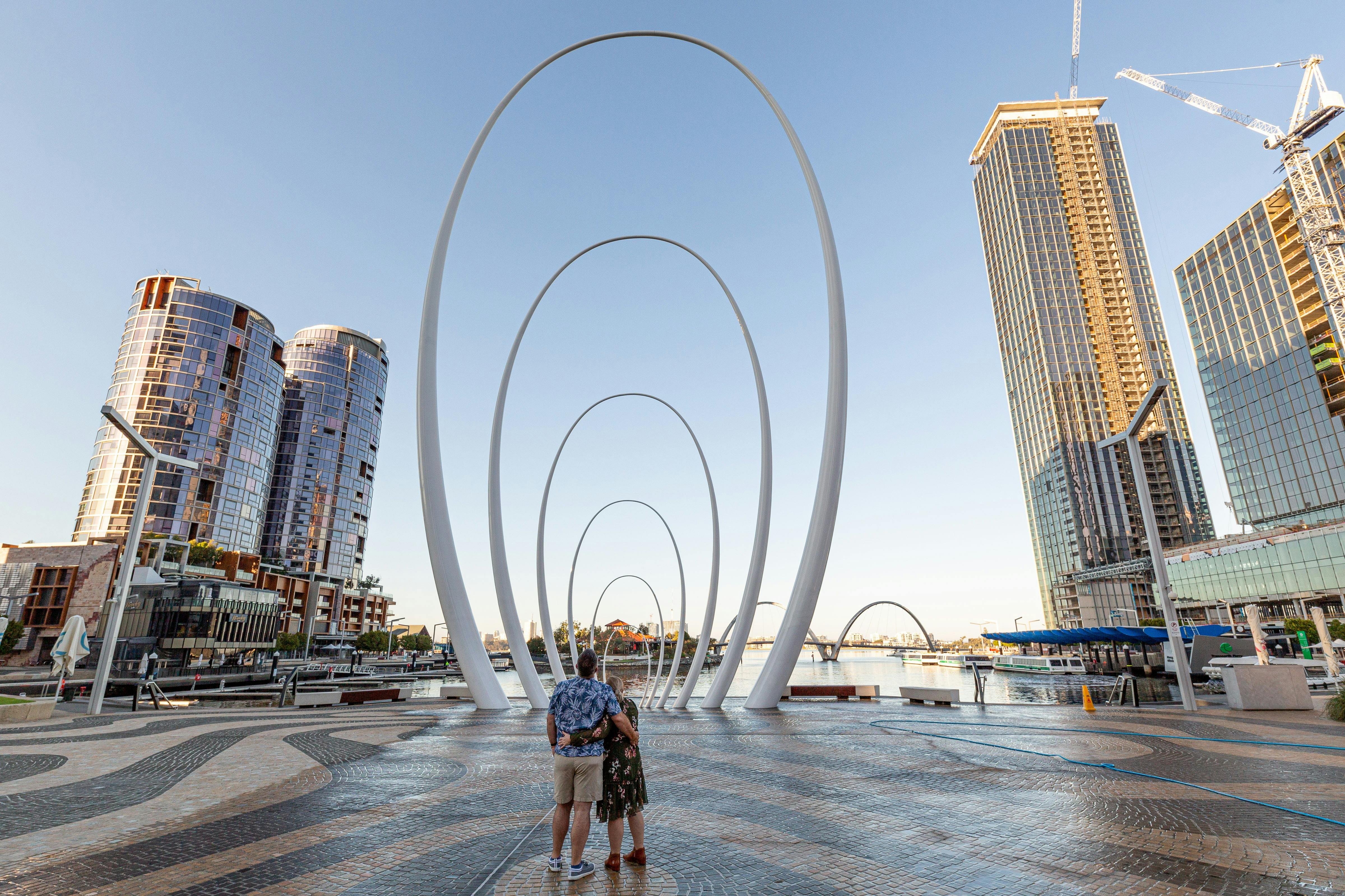 Couple in front of public art surrounded by buildings