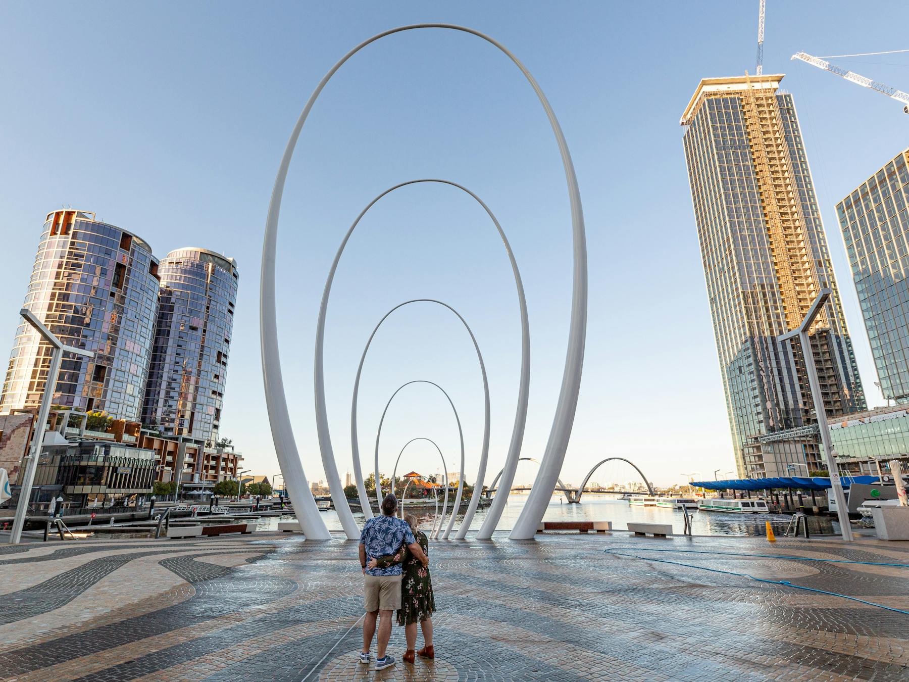 Couple in front of public art surrounded by buildings