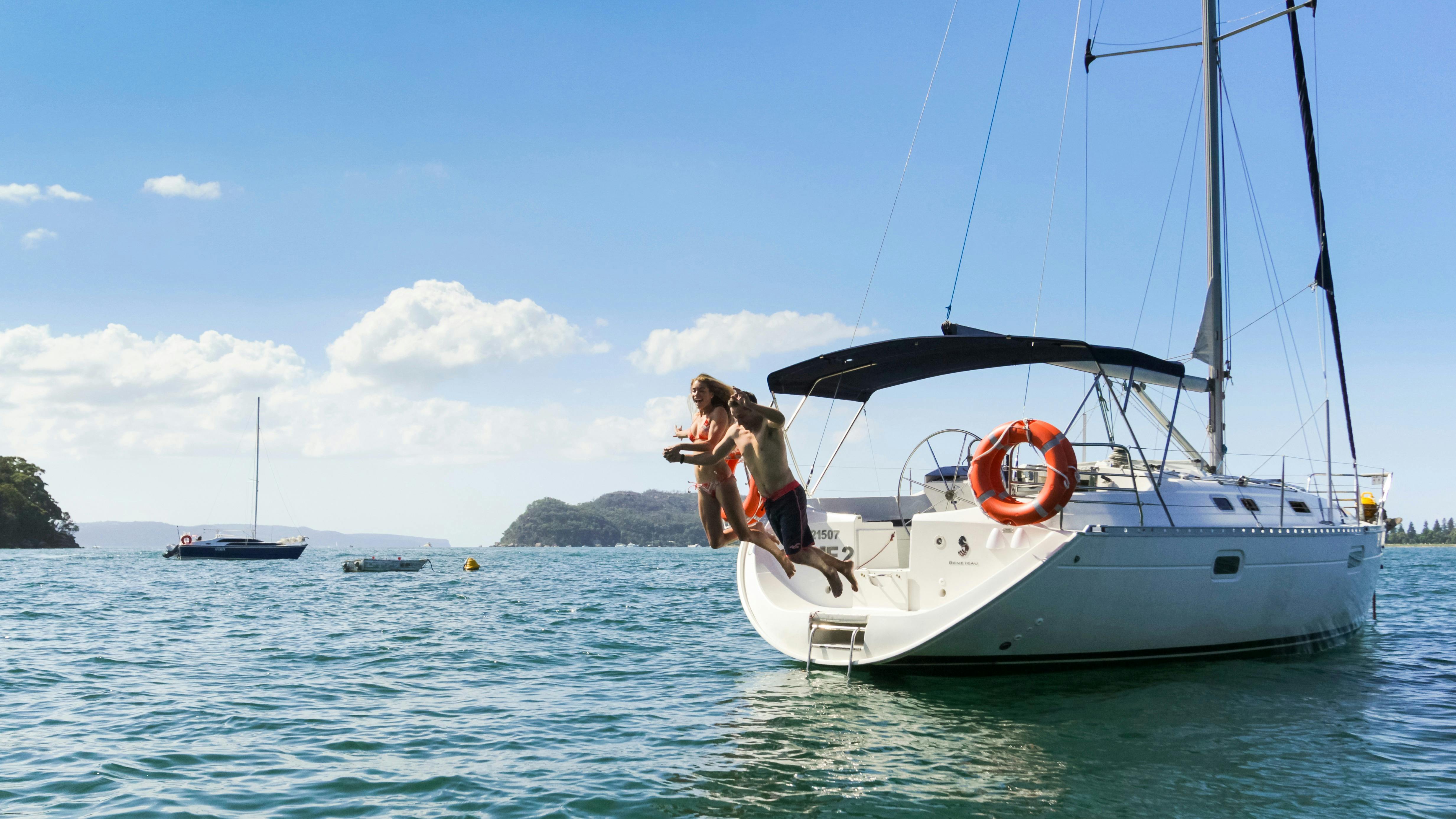 Man and lady jumping off a Taylor Made Escapes yacht in beautiful Pittwater