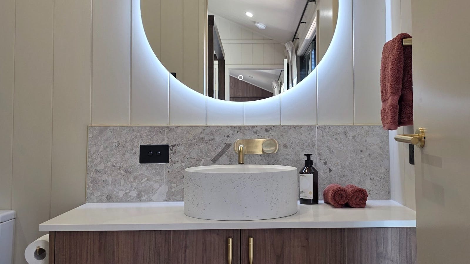 Stylish vanity with heated tile floors and soft towels warmed on the heated towel rail