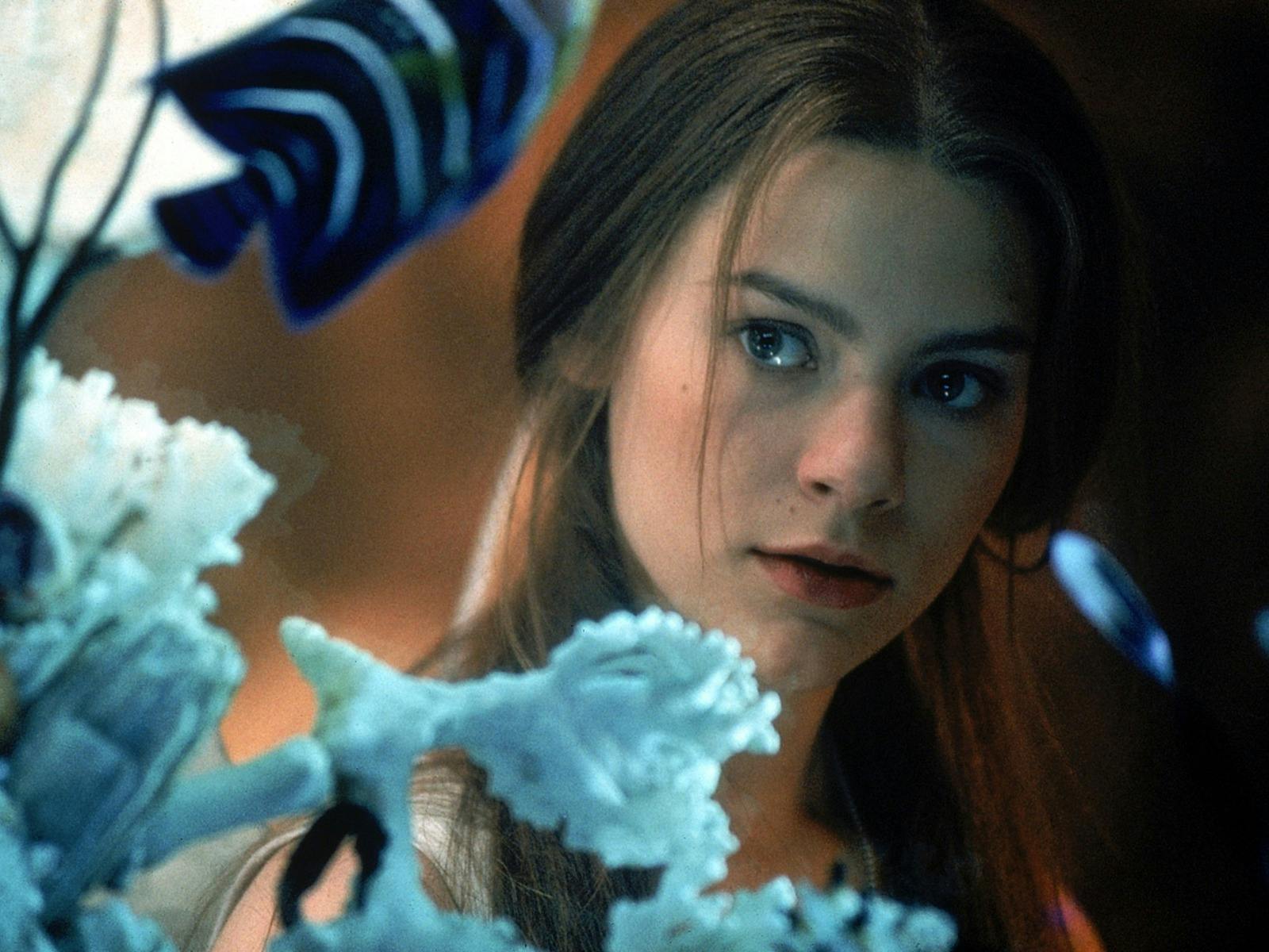 Young woman looks through aquarium