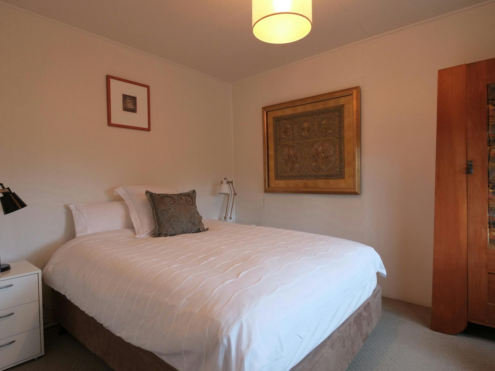 Queen size bedroom with duck feather doona and wool blankets.