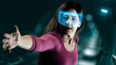 Lady with glowing VR headset reaching out to a camera in escape room