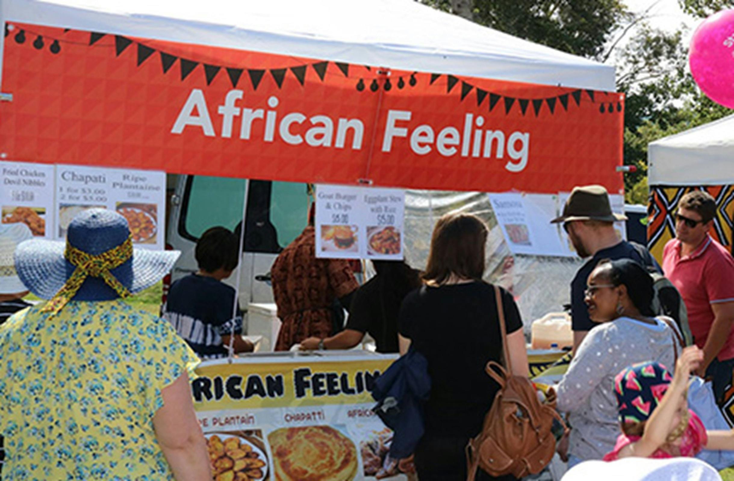 Image of 'African Feeling' food market stall with people queueing to purchase