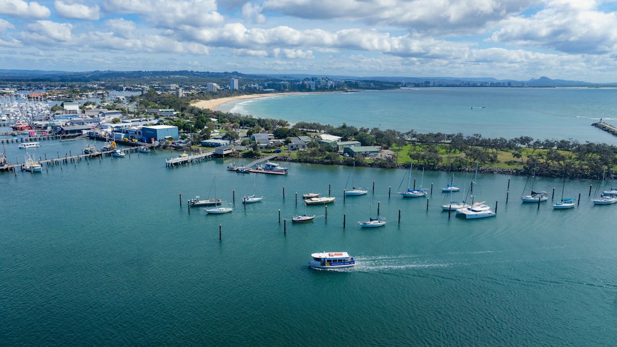 An aerial image of the Mooloolaba Ferry on the water leaving Mooloolaba Beach. An aerial image of the Mooloolaba Ferry on the water leaving Mooloolaba Beach.