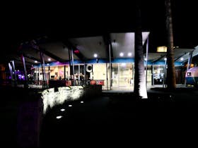 A glass fronted hall lit up at night