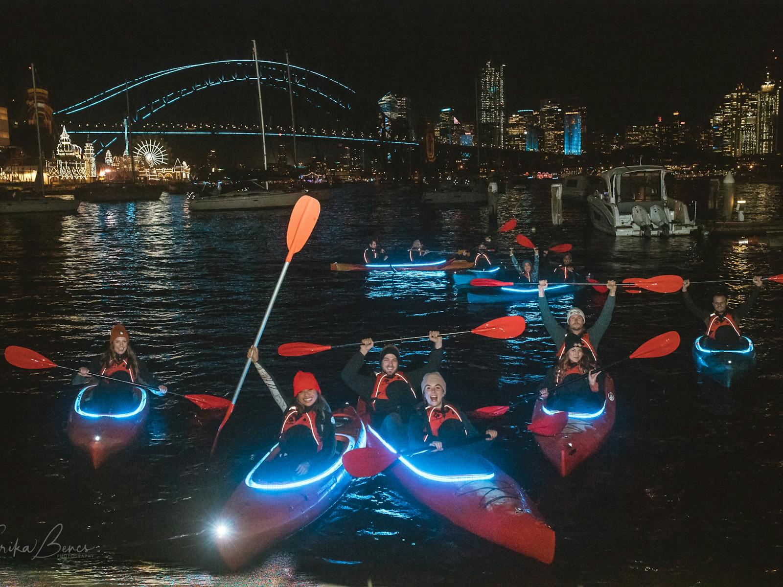 象徴的な港の前で特注のライト付きカヤックに乗ったカヤックのグループ