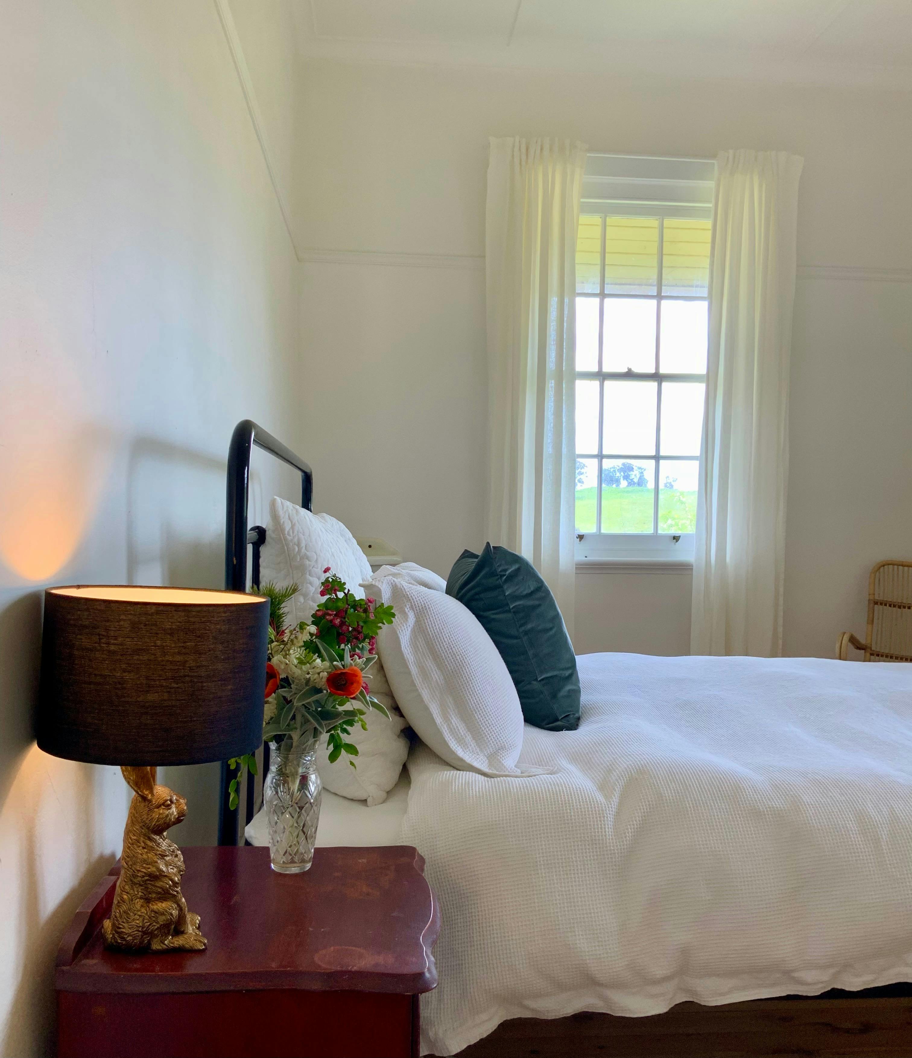 Charming lamps and beautiful Australian artwork feature in this bedroom.