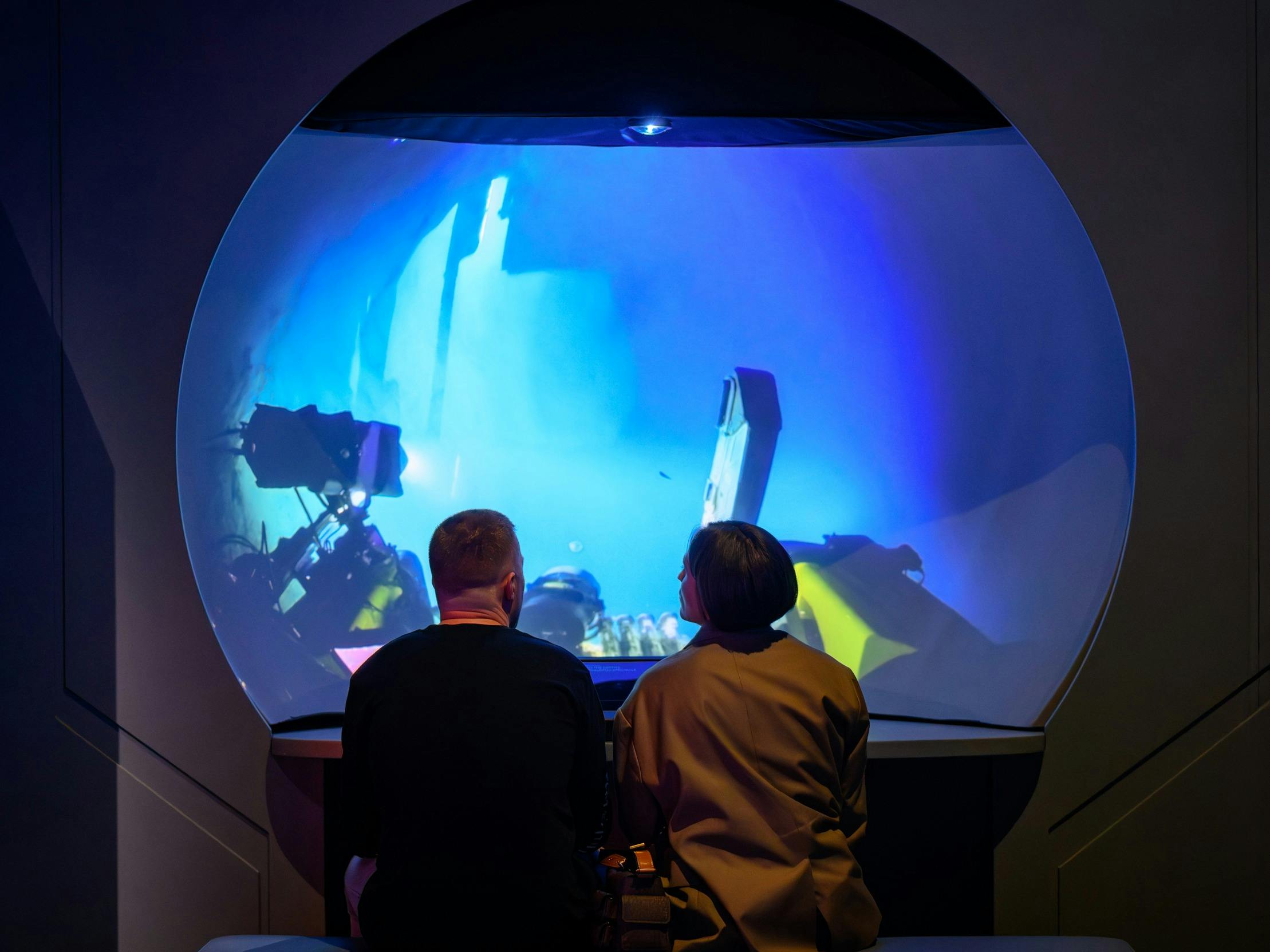 Two people watching a video on a circular screen