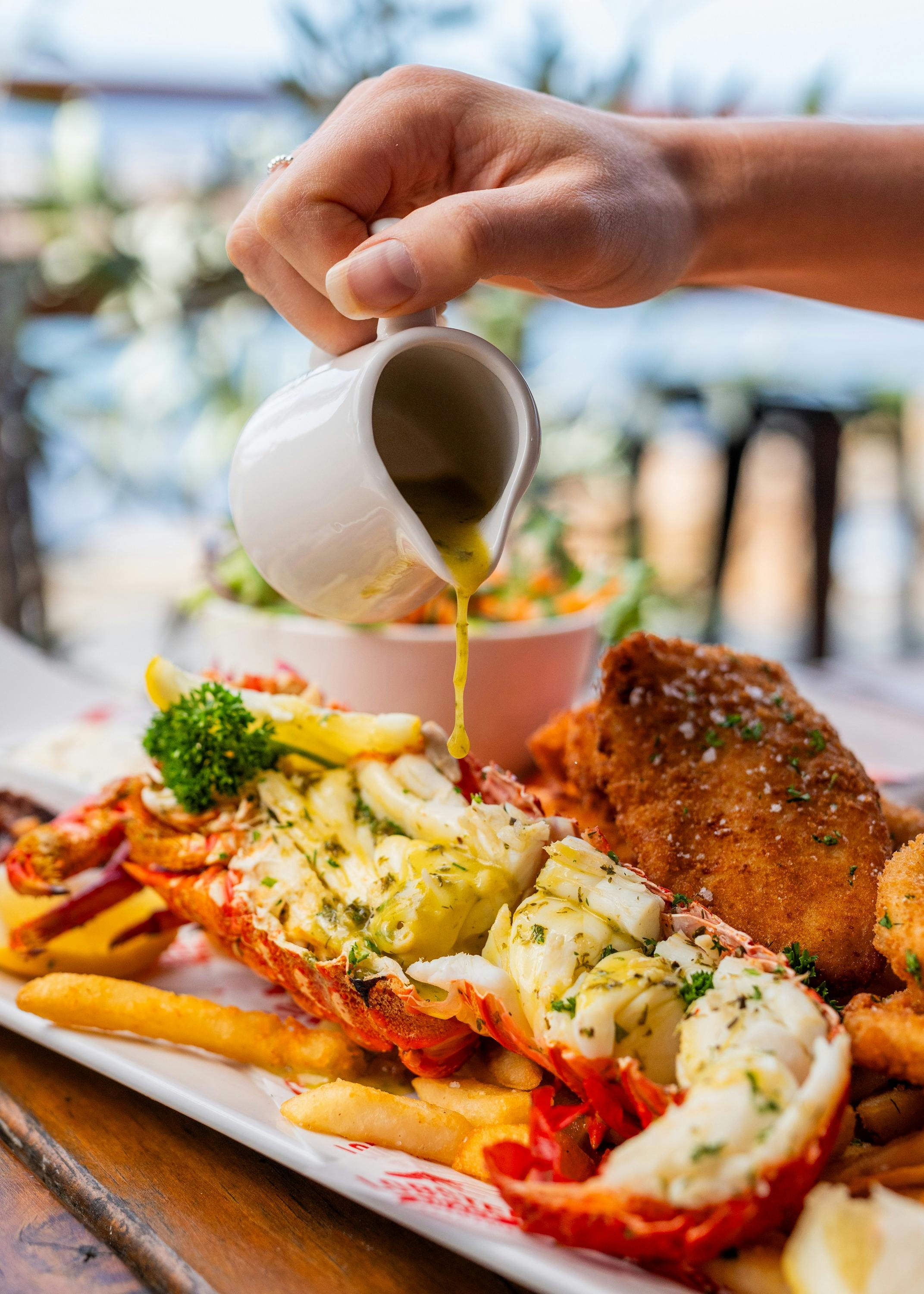Cropped photo of a seafood platter with a half southern rock lobster with garlic butter sauce