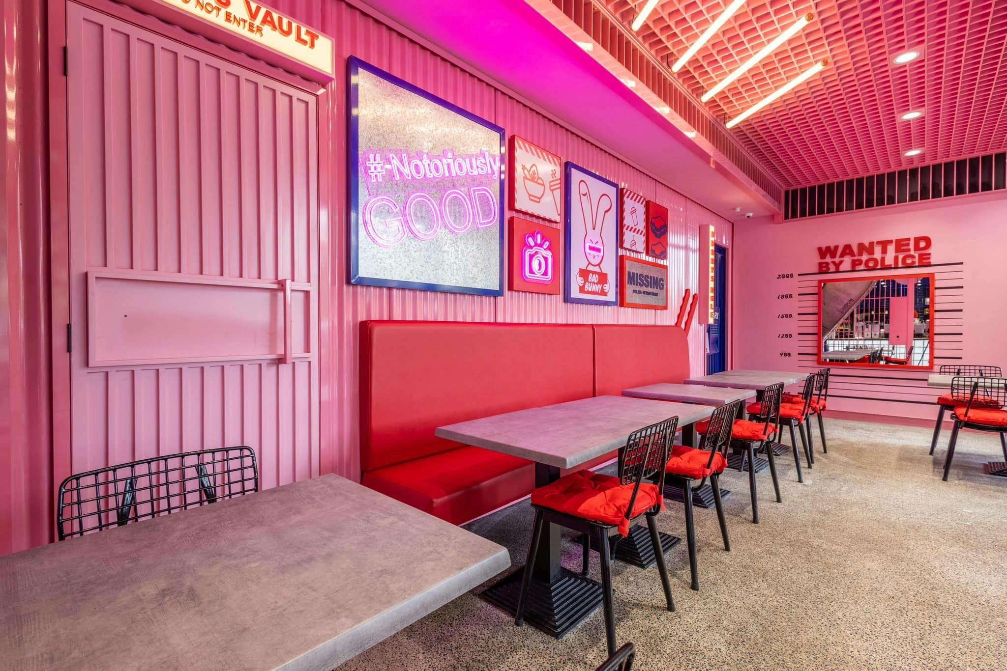 Bright-pink interior decorated with various props. Red booths. (Bad Bunny's interior)