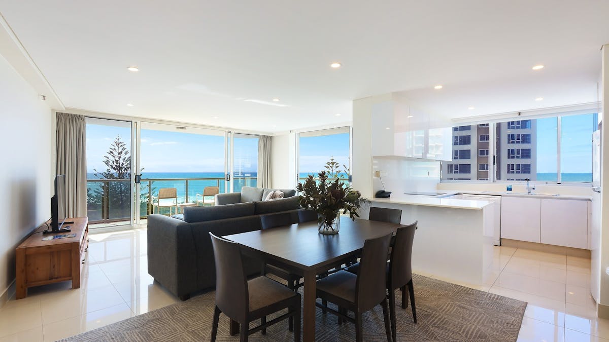Open plan living with dining room, kitchen and lounge room flowing into the balcony with ocean views