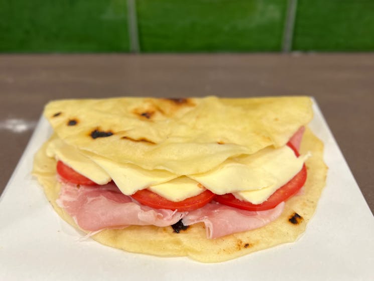 The Italian's toastie. Homemade flatbread with locally smoked ham, true vine ripened tomato & cheese