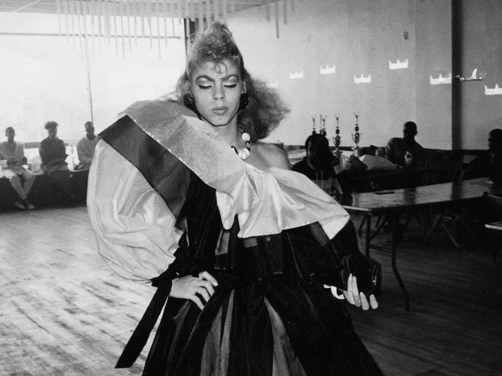 a black-and-white image of a performer in a ball gown.