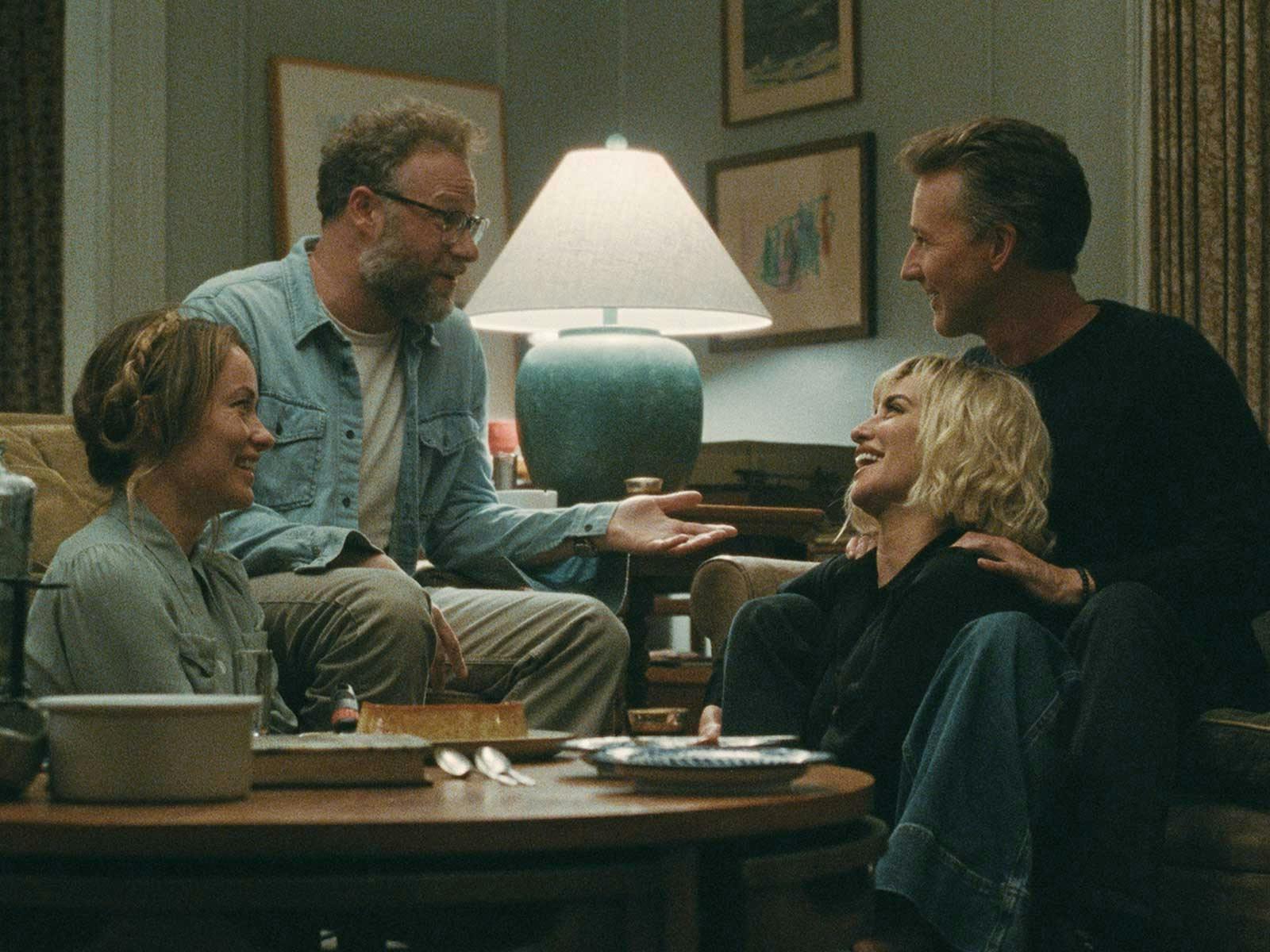 Two couples laugh together in an apartment