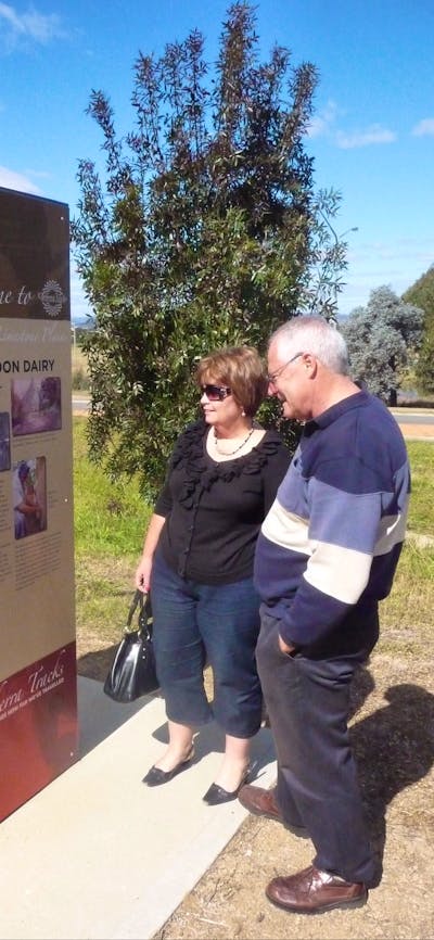 Man and Woman outdoors looking at tall sign
