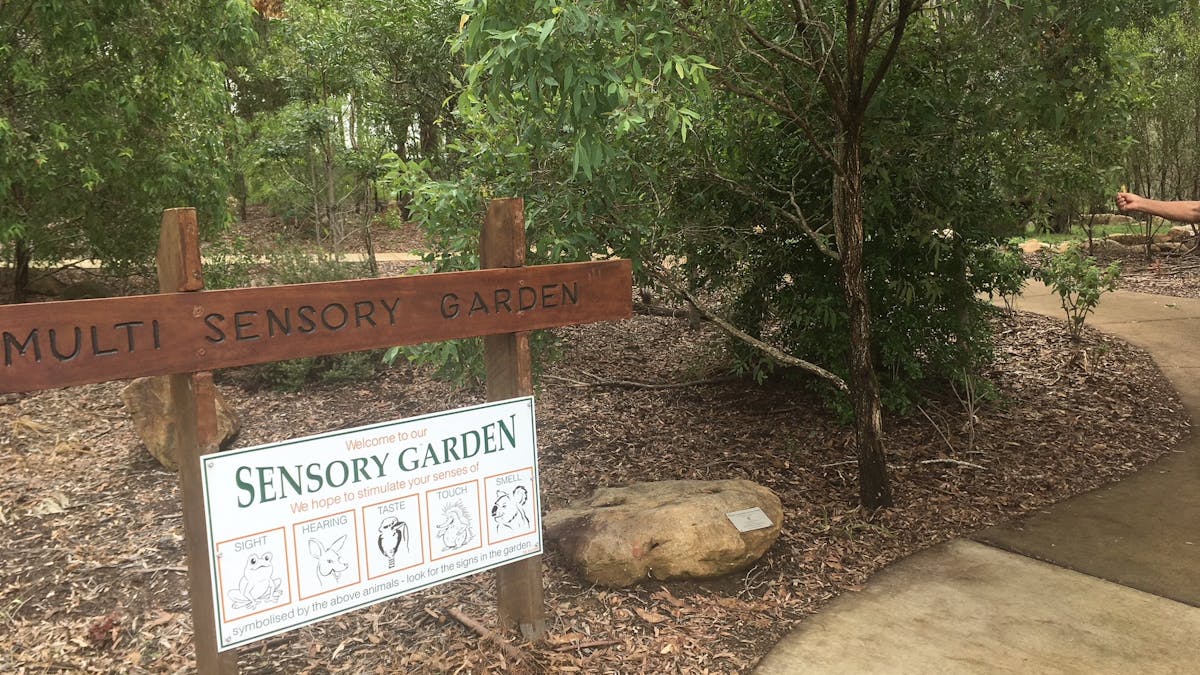 Park reserve with a sign indicating a sensory garden area