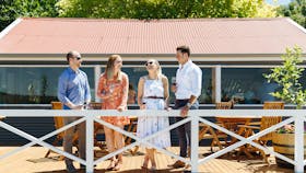 A group of four stand on the new Ashton Hills timber deck and take in the view