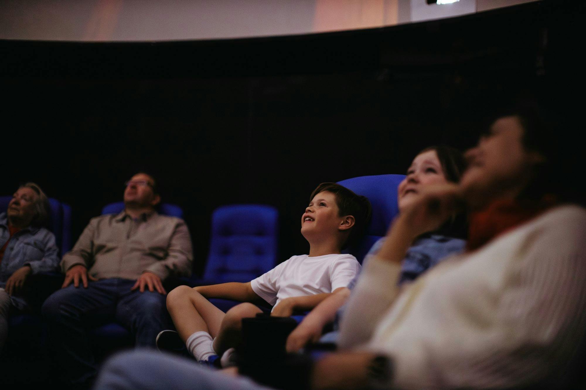 A family looks up at the Planetarium full-dome screen