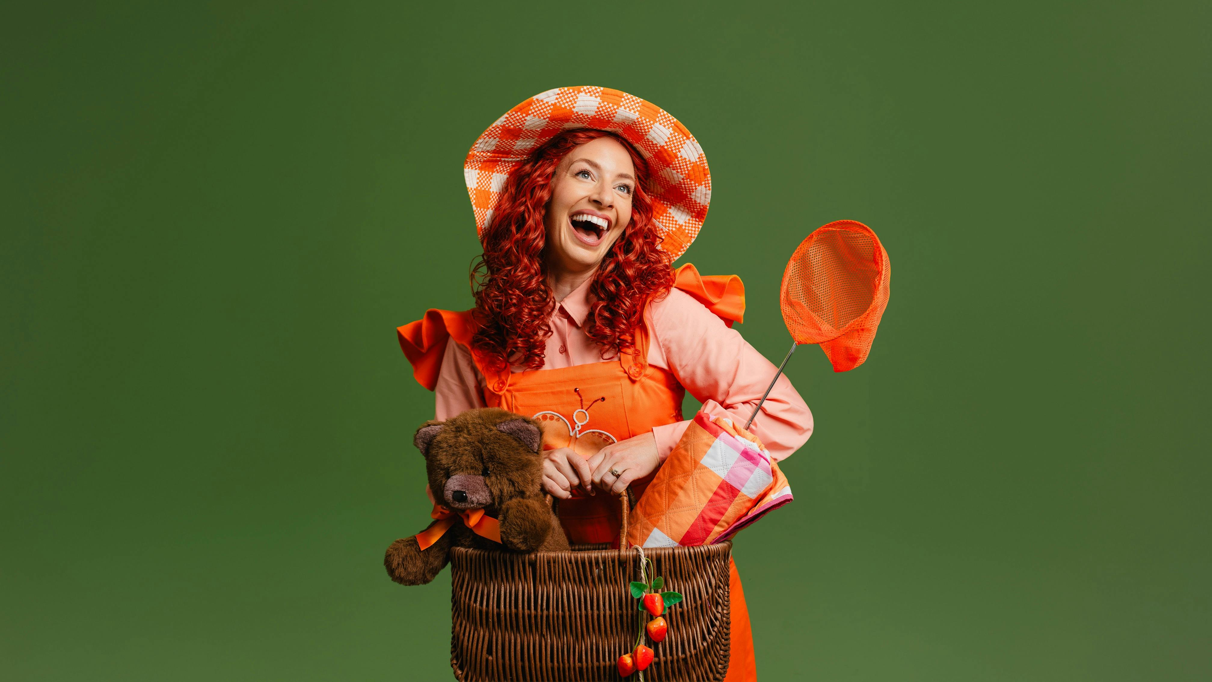 Emma Memma in an orange dress with a picnic basket and a net