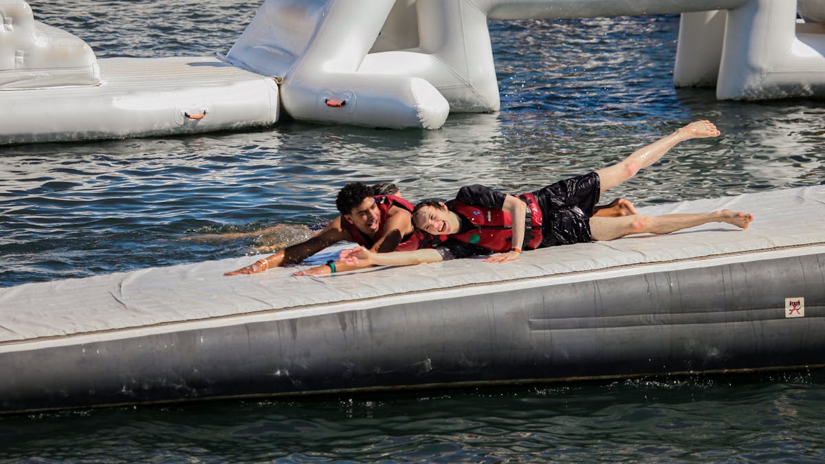 Two people sliding down running sliding