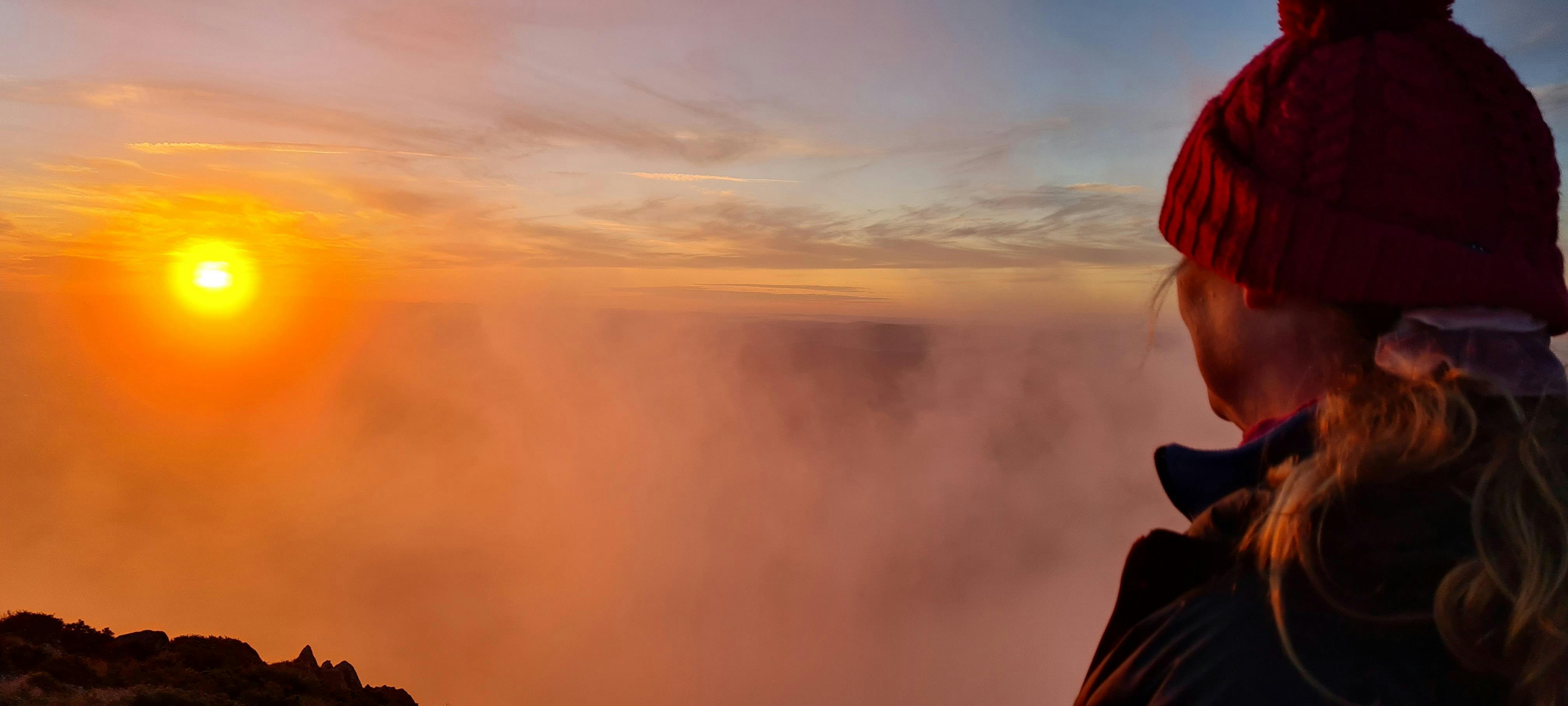 A hiker mesmerised by a setting sun