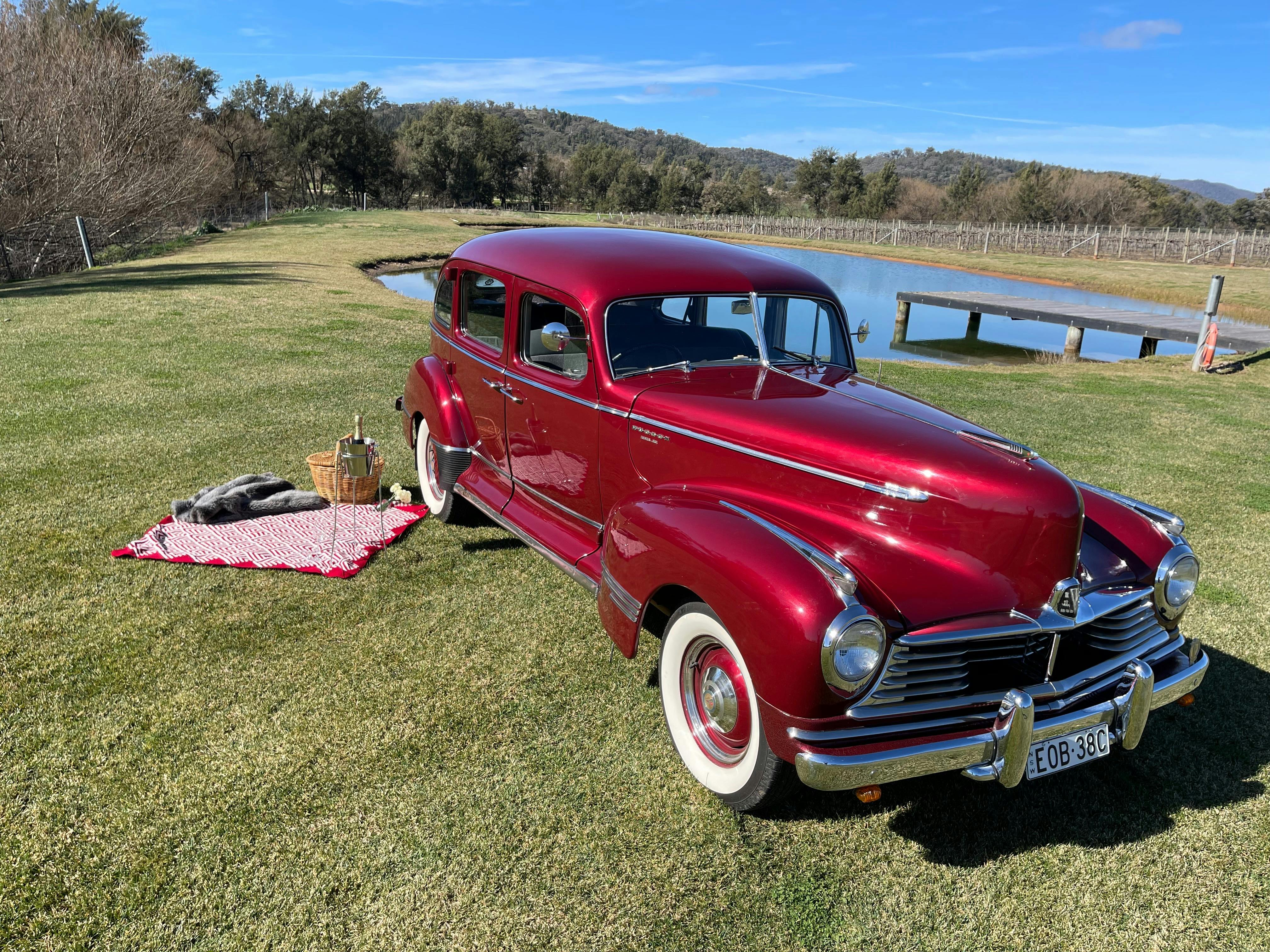 Red vintage car with picnic rug