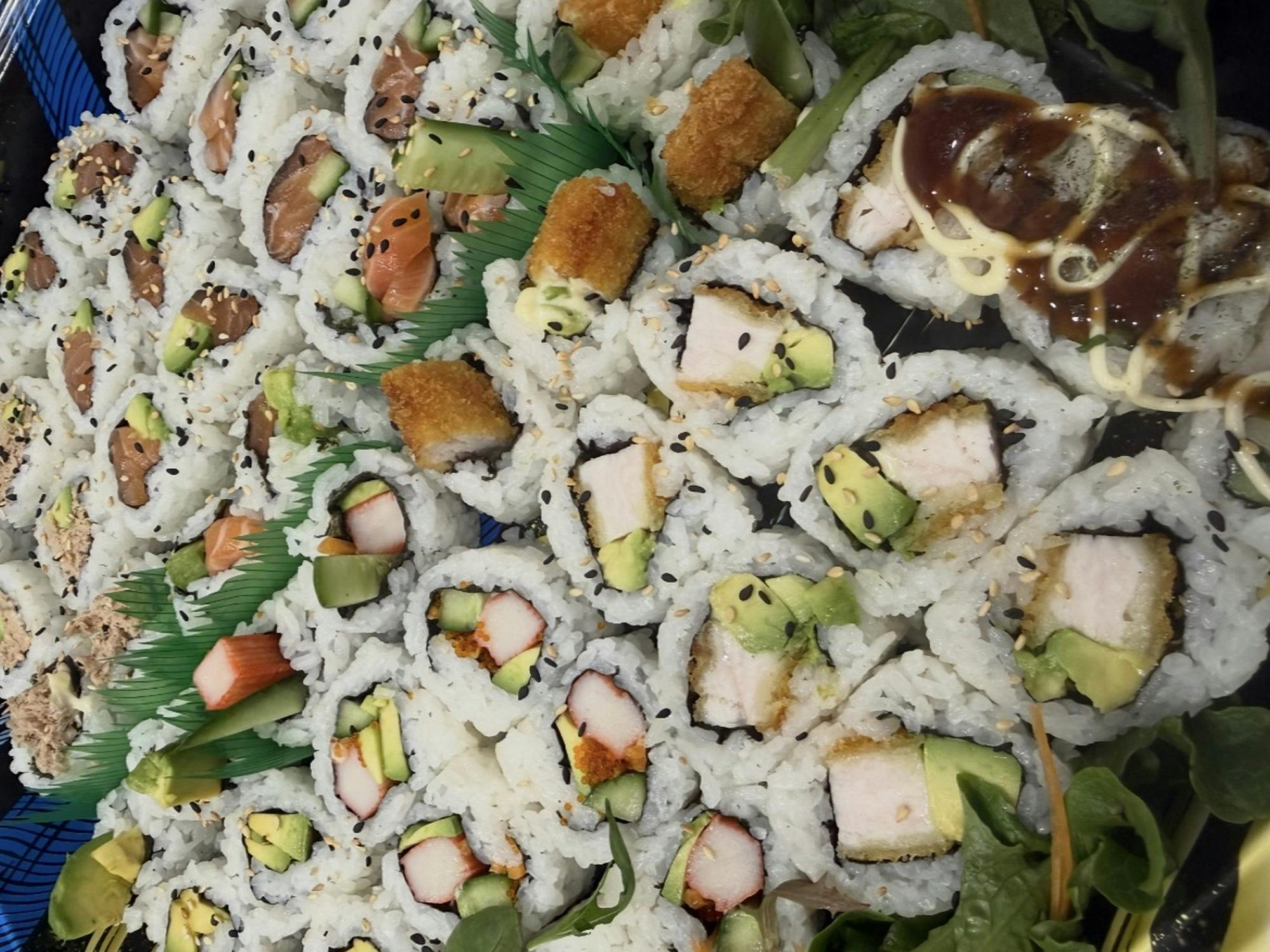 A platter of assorted medium-sized inside-out sushi rolls, with variety to choose from!