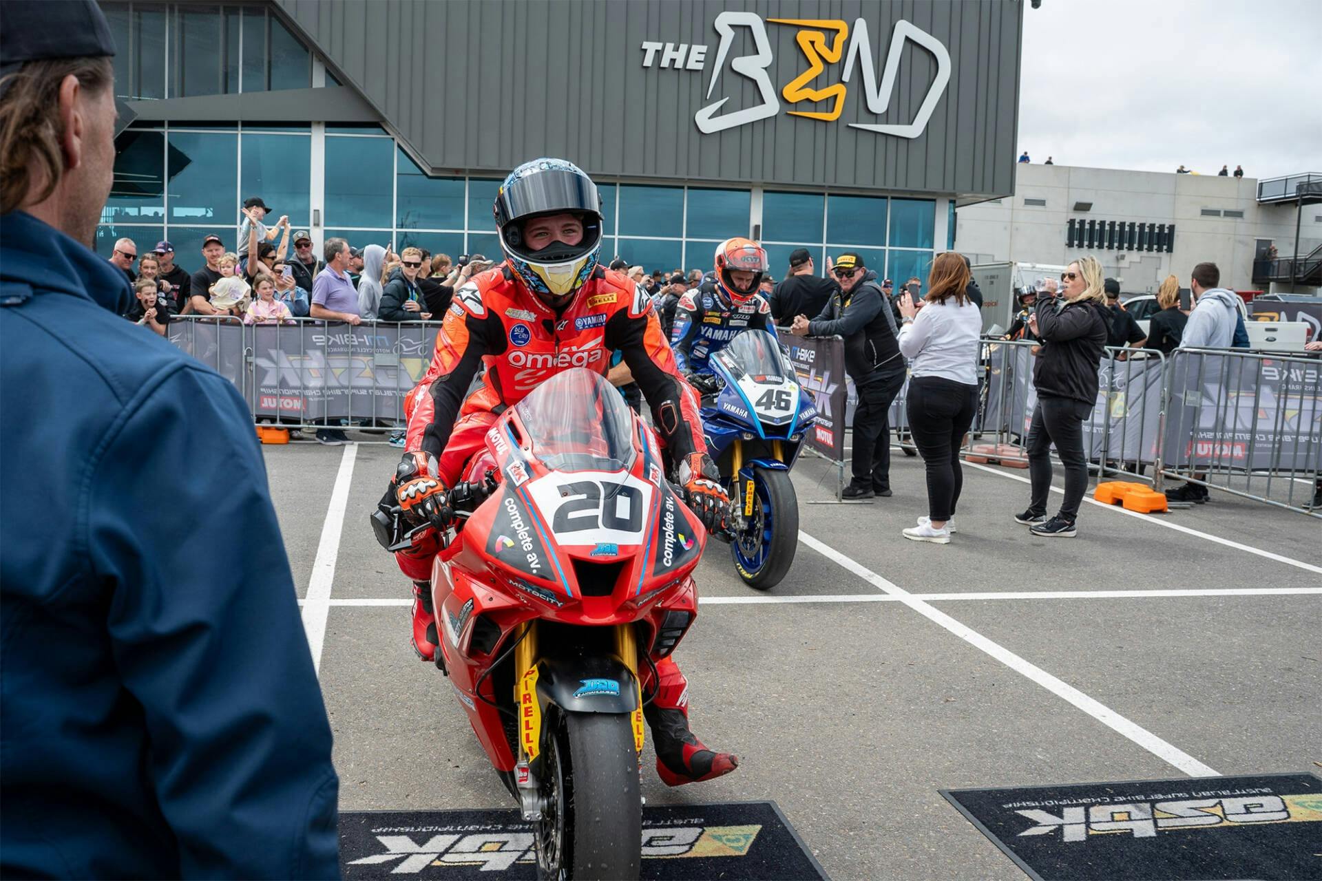 Riders pull up to the podium on their bikes