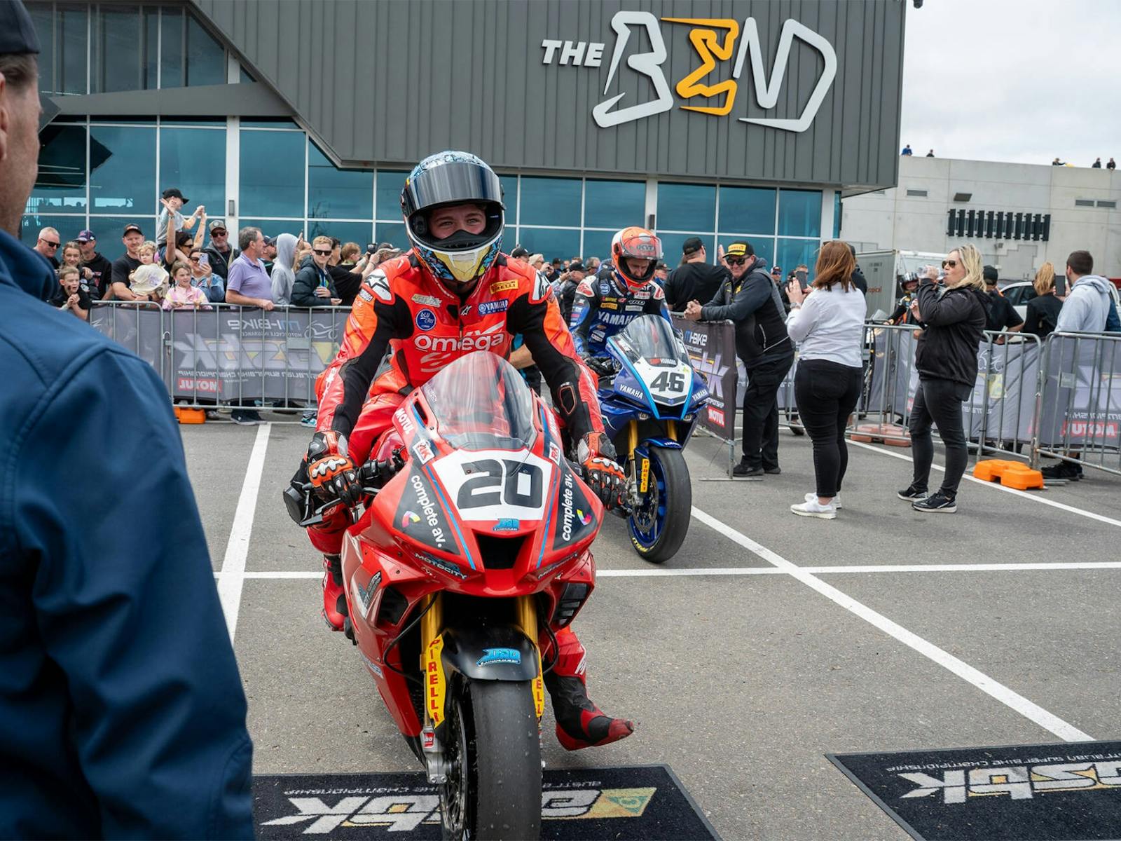 Riders pull up to the podium on their bikes